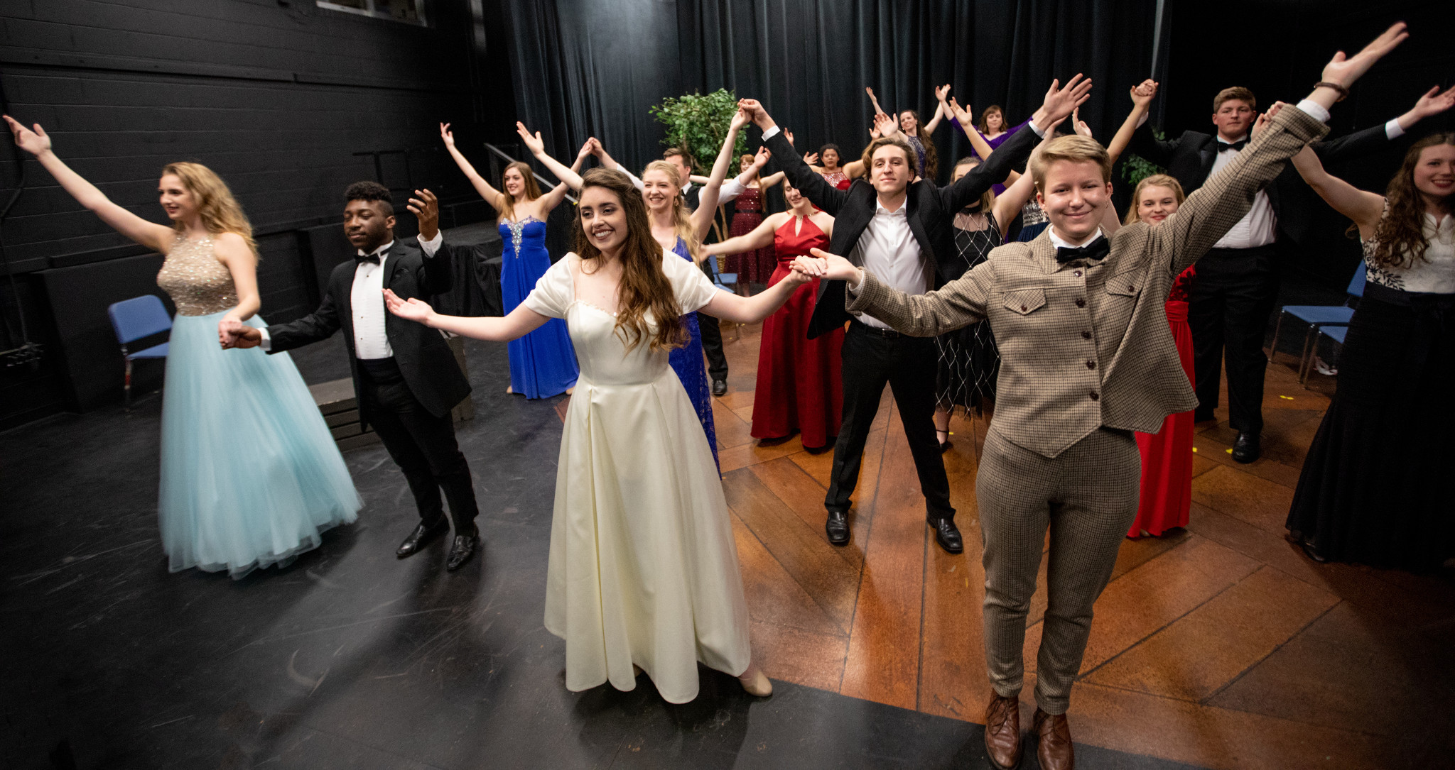 students in costumes on a stage ready to take a bow